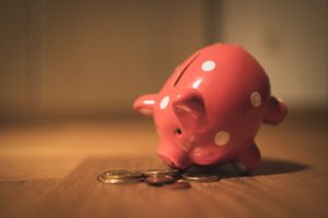 Piggybank and coins on the floor - Why is it hard to save money